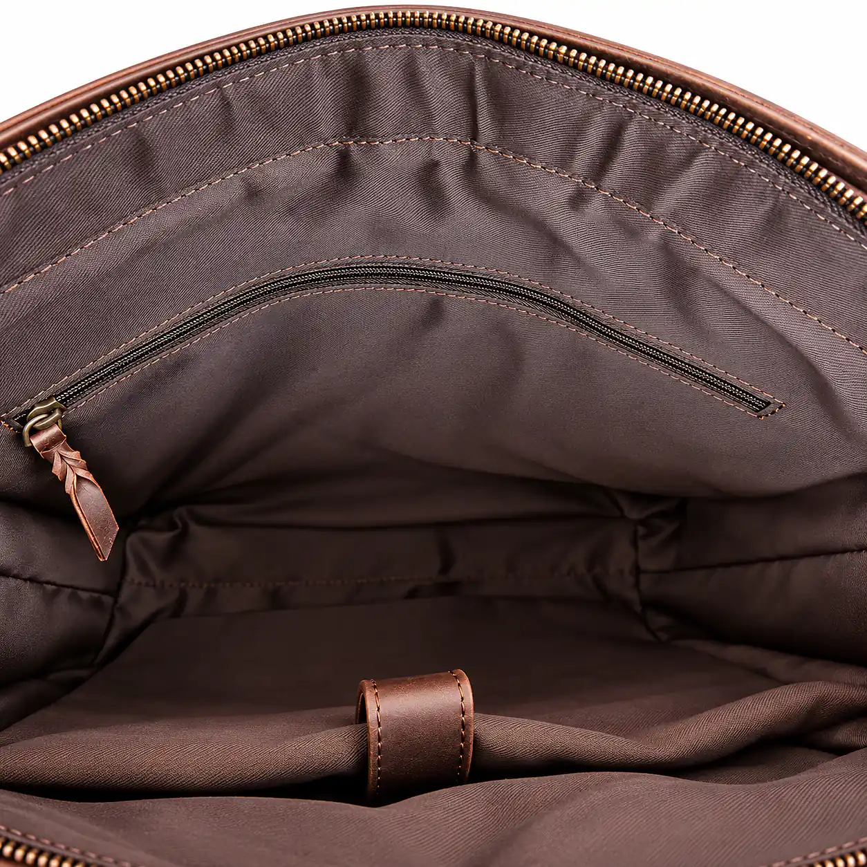 Close-up of brown bag interior showing lining stitching and internal zipped pocket